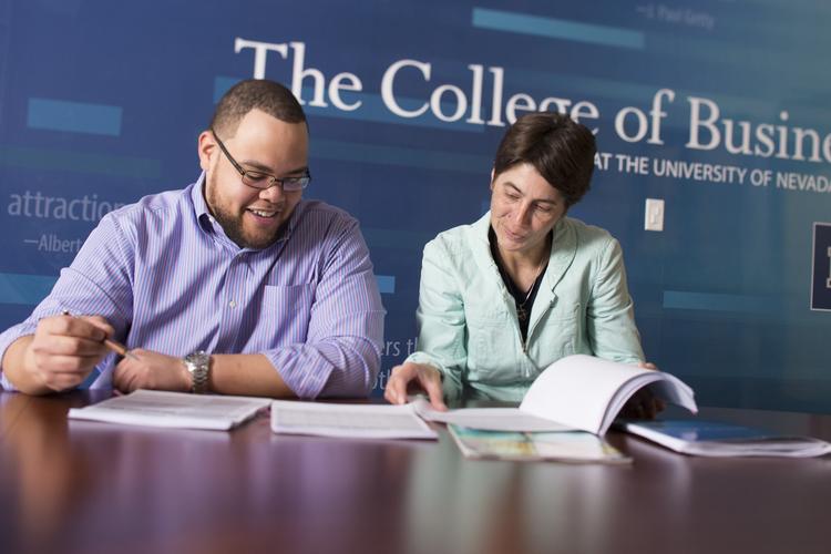 Business faculty and student at desk